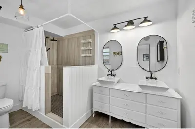 a white bathroom with two sinks and two mirrors at Kelowna full level luxury-BIG white ski 35 mins in Kelowna