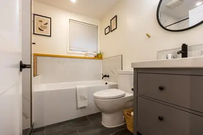 a bathroom with a toilet and a tub and a sink at Elkview by Fernie Central Reservations in Fernie