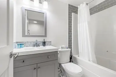 a white bathroom with a sink and a toilet at Marvellous Poolside Chalet - Pool & Hot Tub - Pets in Canmore