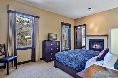 a bedroom with a bed and a fireplace at Fantastic Mountain View - Hot Tubs & Steam Room in Canmore