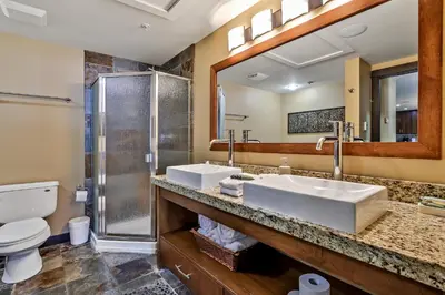 a bathroom with two sinks and a shower at Fantastic Mountain View - Hot Tubs & Steam Room in Canmore