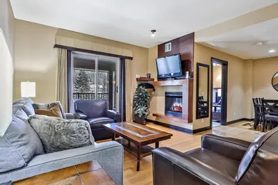 a living room with a couch and a fireplace at Fantastic Mountain View - Hot Tubs & Steam Room in Canmore