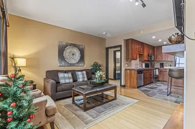a living room with a christmas tree in it at Stunning Condo - Hot Tubs & Steam Room - Pets Ok in Canmore