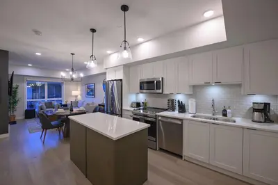 a kitchen with white cabinets and a dining room at Rockies Retreat Getaway Heated Pool &Hot Tub Gym in Dead Man's Flats