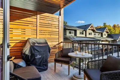 a patio with chairs and a table on a balcony at Rockies Retreat Getaway Heated Pool &Hot Tub Gym in Dead Man's Flats