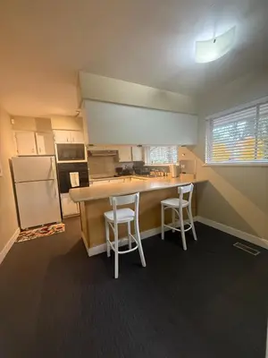 a kitchen with a counter and two stools at The Sunshine Haven in Delta