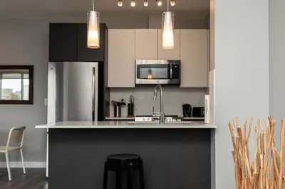a kitchen with a sink and a refrigerator at Corporate Stays Village on 105 1 Bedroom in Edmonton