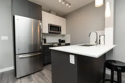 a kitchen with a stainless steel refrigerator and a counter at Corporate Stays Village on 105 1 Bedroom in Edmonton