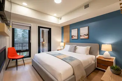a bedroom with a large bed and a window at Brand New Canmore Studio - Cozy Mountain Getaway in Canmore