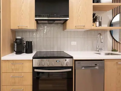 a kitchen with a stove and a sink at Brand New Canmore Studio - Cozy Mountain Getaway in Canmore