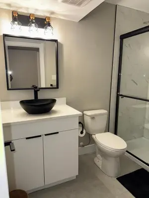 a bathroom with a sink and a toilet and a mirror at NorthEdge Suites in Edmonton