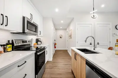 a white kitchen with a sink and a microwave at New 2BR in DT Golden with AC, Balcony, BBQ, Sleeps 6 in Golden