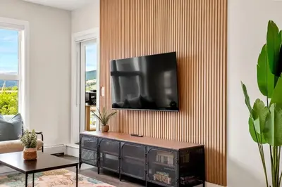 a living room with a television on a wall at New 2BR in DT Golden with AC, Balcony, BBQ, Sleeps 6 in Golden