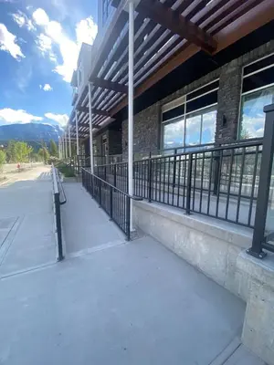an empty sidewalk next to a building with a fence at New 2BR in DT Golden with AC, Balcony, BBQ, Sleeps 6 in Golden