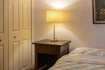 a lamp on a table next to a bed at 2 BDRS at DT-Near 2 metros, Atwater Market, Concordia in Bélanger