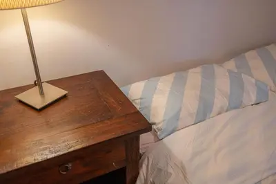 a bed with a wooden table with a lamp on it at 2 BDRS at DT-Near 2 metros, Atwater Market, Concordia in Bélanger