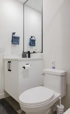 a white bathroom with a toilet and a mirror at Brown Family Vacation Home in Leduc