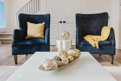 a living room with two blue chairs and a table at Brown Family Vacation Home in Leduc