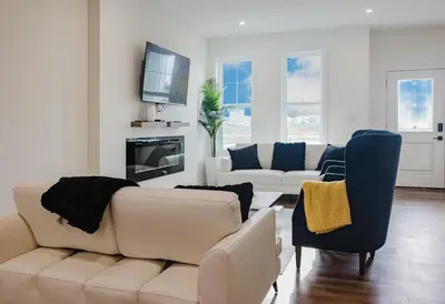 a living room with a couch and chairs and a tv at Brown Family Vacation Home in Leduc