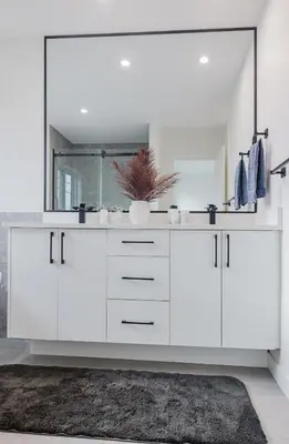 a white bathroom with a sink and a mirror at Brown Family Vacation Home in Leduc