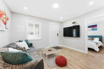 a living room with a couch and a tv at Lovely Coach House in Langley with Queen Beds Pkg in Langley