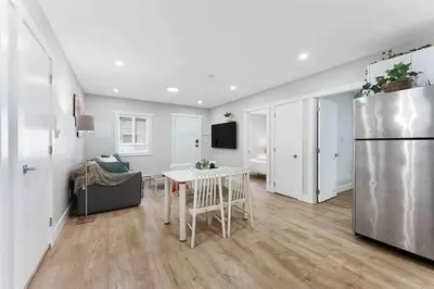 a kitchen and living room with a refrigerator and a table at Lovely Coach House in Langley with Queen Beds Pkg in Langley