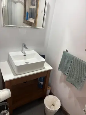 a bathroom with a sink and a mirror and a toilet at maison de la Ferme in Bélanger