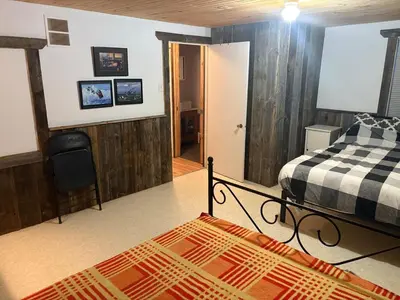 a bedroom with two beds and a hallway with a door at maison de la Ferme in Bélanger