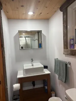 a bathroom with a sink and a mirror at maison de la Ferme in Bélanger