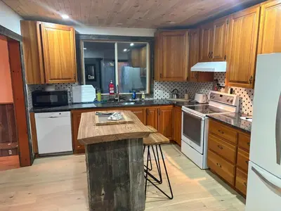 a kitchen with wooden cabinets and a wooden counter top at maison de la Ferme in Bélanger