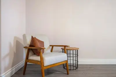 a chair with a pillow sitting in a room at The Arizona 2BR Pet-Friendly Suite Calgary SE in Calgary