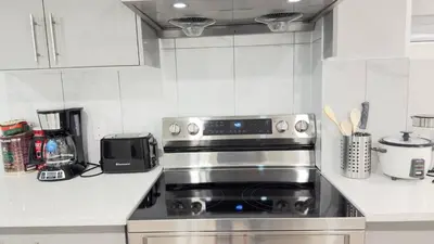 a kitchen with a stainless steel stove top oven at Zillion’s Bliss - Basement Suite in Calgary