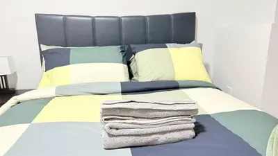 a bed with a pile of towels on it at Zillion’s Bliss - Basement Suite in Calgary