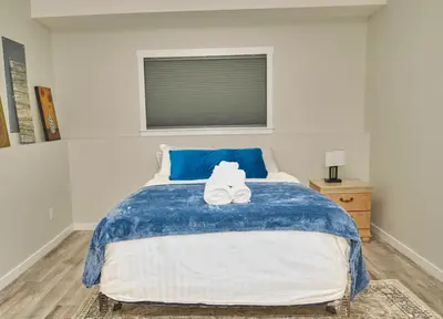 a bedroom with a bed with two white shoes on it at Anukc in Prince George