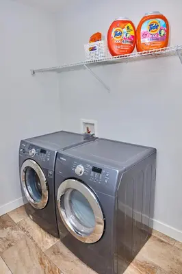a washing machine in a room with a shelf at Anukc in Prince George