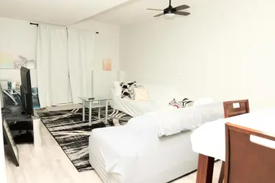 a white living room with a bed and a table at Anukc in Prince George