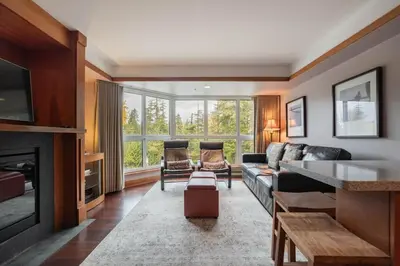 a living room with a couch and a fireplace at Le Chamois 307 by Outpost Whistler in Whistler