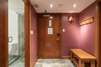 a room with a wooden door and a wooden table at Le Chamois 307 by Outpost Whistler in Whistler