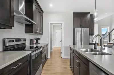 a kitchen with wooden cabinets and stainless steel appliances at The Herron Rise Retreat in Calgary