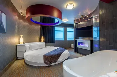 a bedroom with a large bed and a tv at Applause Hotel Calgary Airport by CLIQUE in Calgary