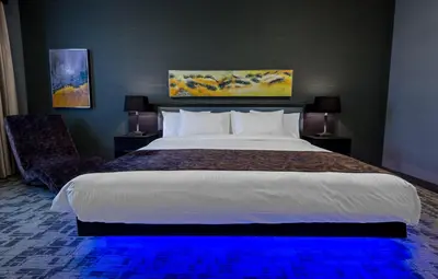 a bedroom with a large bed with a blue light at Applause Hotel Calgary Airport by CLIQUE in Calgary
