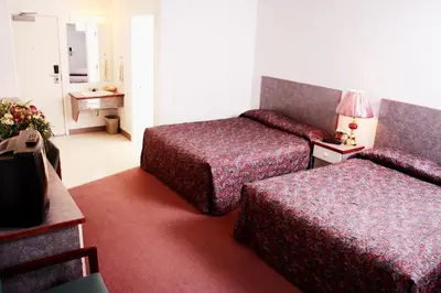 a hotel room with two beds and a table at Country Club Inn in Lacombe