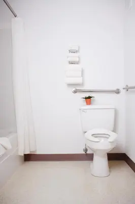 a bathroom with a white toilet and a shower at Country Club Inn in Lacombe