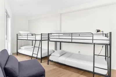 two bunk beds in a room with a couch at 4BR Luxury Mountain Retreat Private HotTub Sleeps 17 in Canmore