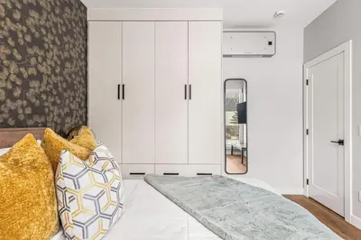 a bedroom with a bed and white cabinets at Luxury 4BR with Hot Tub Mtn Views 10Min Walk to DT in Canmore