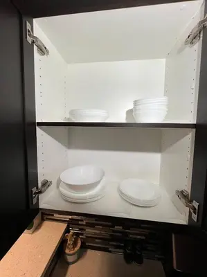 a cabinet filled with white plates and bowls at Cozy 2BR Retreat | Edmonton SW | Smart TV + Wi-Fi in Edmonton