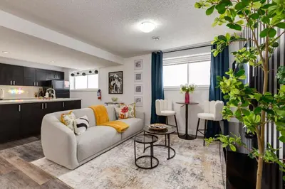 a living room with a couch and a kitchen at Urban Retreat Suits 2 Bedroom & Feature Packed in Calgary