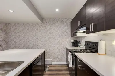 a kitchen with a sink and a stove at Urban Retreat Suits 2 Bedroom & Feature Packed in Calgary