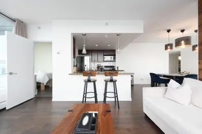 a living room with a white couch and a table at Sub-Penthouse Condo with Jacuzzi Pool Sauna & Gym in Vancouver