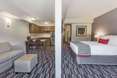 a hotel room with a bed and a kitchen at Microtel Inn and Suites by Wyndham Kitimat in Kitimat